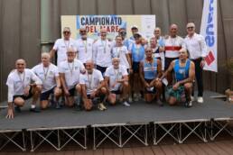 Foto di gruppo dei canottieri con le medaglie davanti al pannello dei Campionati del Mare 2026 a Genova Pra’