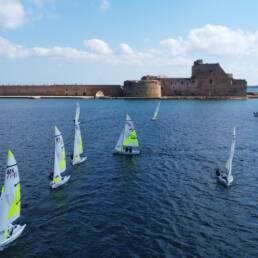 Barche RS Feva nel porto di Brindisi, con il castello sullo sfondo, riprese dal drone al Trofeo CONI 2026